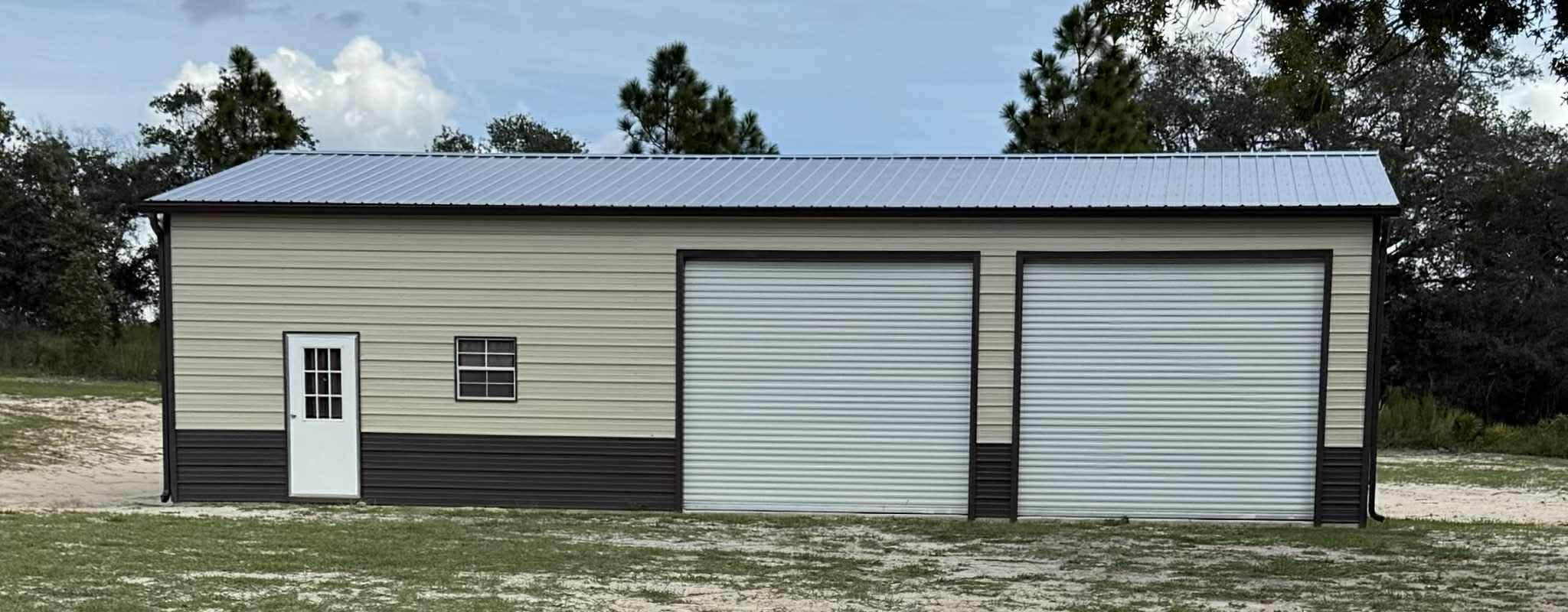 Tan and brown metal building with two roll-up garage doors