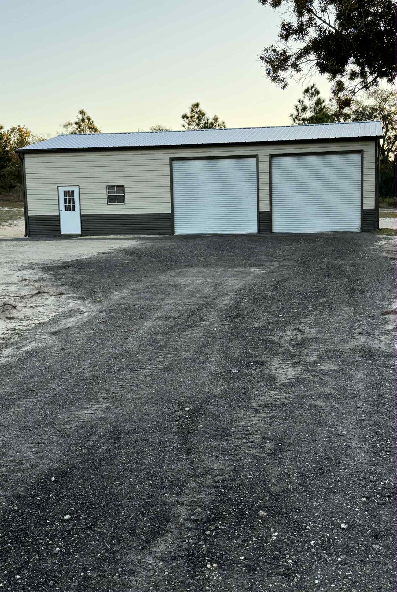 Tan metal garage with two roll-up doors